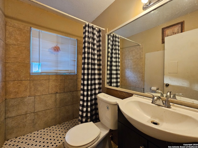 bathroom featuring a textured ceiling, toilet, vanity, and walk in shower