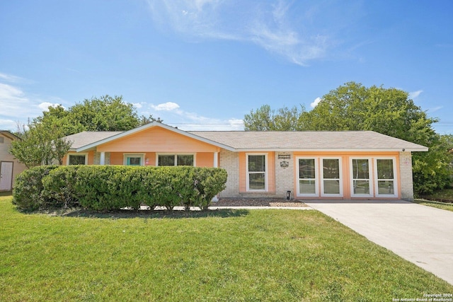 single story home with brick siding and a front yard