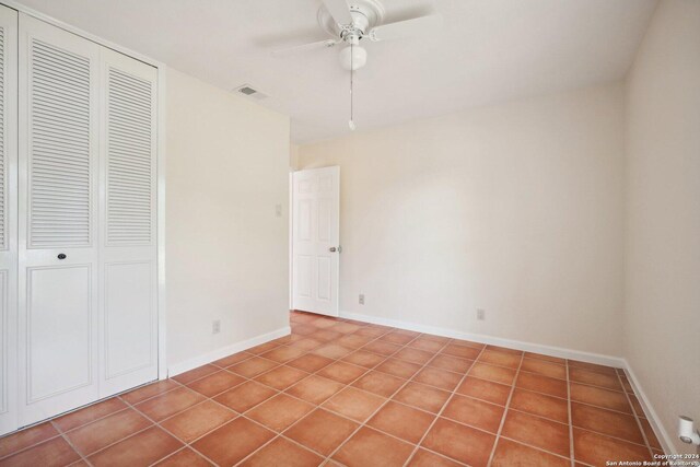 unfurnished bedroom with ceiling fan, tile patterned flooring, and a closet