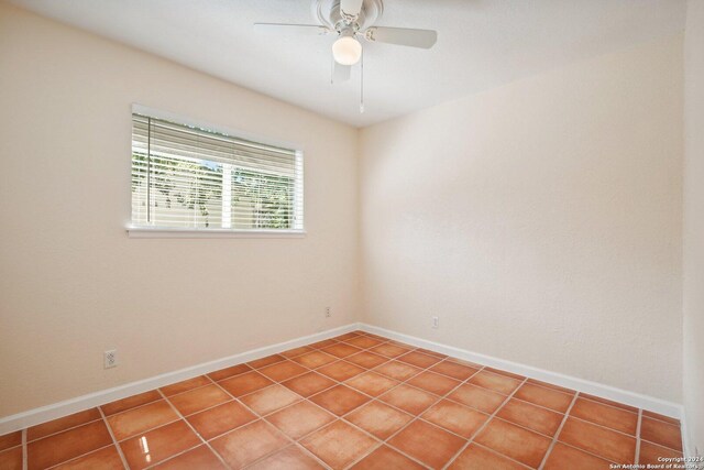 tiled spare room featuring ceiling fan