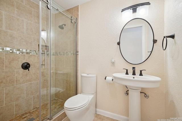 bathroom with baseboards, a shower stall, and toilet