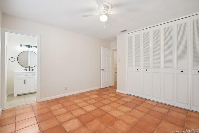 unfurnished bedroom with ceiling fan, a closet, sink, connected bathroom, and light tile patterned flooring