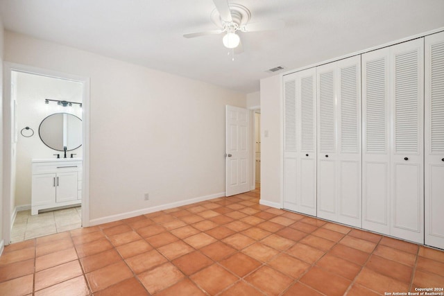 unfurnished bedroom with light tile patterned flooring, a sink, visible vents, baseboards, and a closet