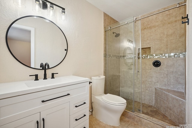 bathroom featuring tile patterned flooring, toilet, vanity, and a shower with shower door