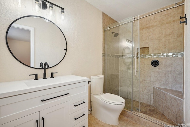 bathroom featuring toilet, a shower stall, vanity, and tile patterned floors