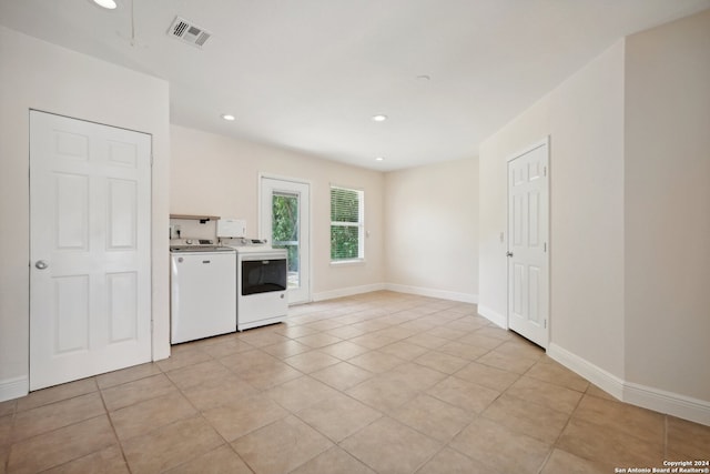 unfurnished living room with light tile patterned flooring and separate washer and dryer