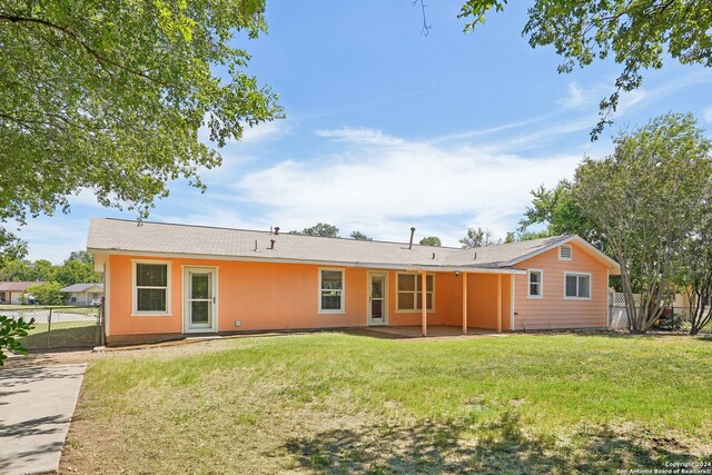 rear view of house with a patio area and a lawn