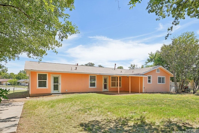 back of property featuring fence, a patio, and a yard