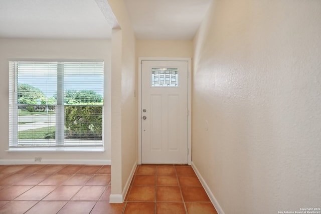 doorway to outside with plenty of natural light and tile patterned flooring