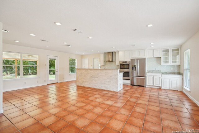 unfurnished living room featuring plenty of natural light and light tile patterned flooring