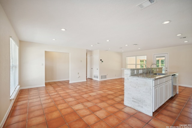 kitchen featuring dishwasher, white cabinetry, sink, a kitchen island with sink, and light tile patterned floors