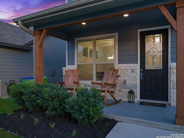 exterior entry at dusk featuring covered porch