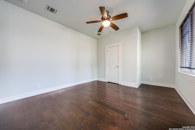 unfurnished room featuring ceiling fan, baseboards, visible vents, and dark wood finished floors