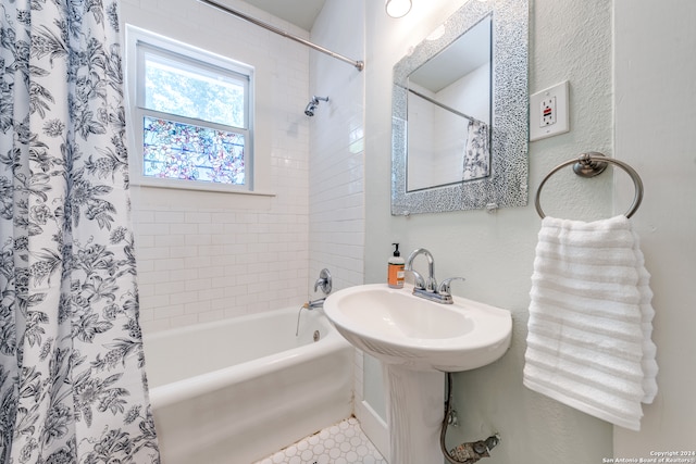 bathroom featuring tile patterned flooring, shower / tub combo, and sink