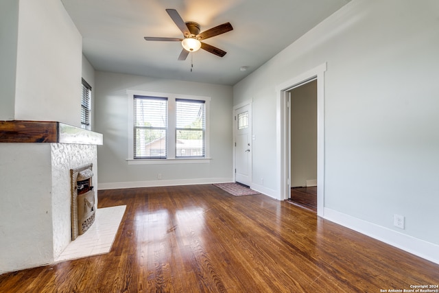 unfurnished living room with ceiling fan and dark wood-type flooring