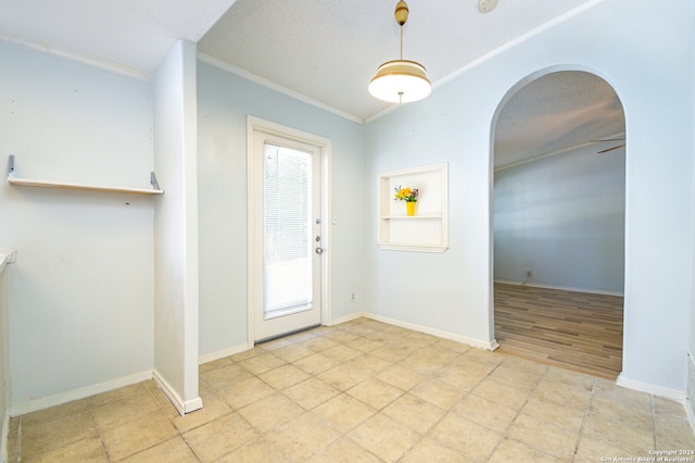 doorway with ceiling fan, a textured ceiling, light tile patterned flooring, and ornamental molding