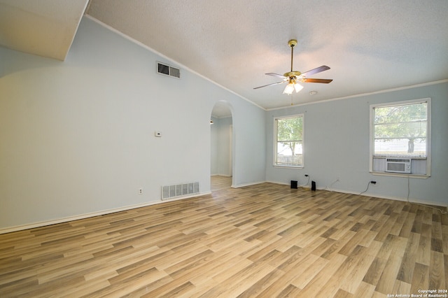 unfurnished room with light hardwood / wood-style flooring, cooling unit, crown molding, lofted ceiling, and ceiling fan