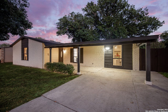 single story home featuring a lawn