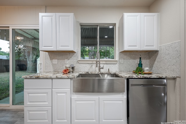 kitchen featuring sink, white cabinets, stainless steel dishwasher, and light stone countertops