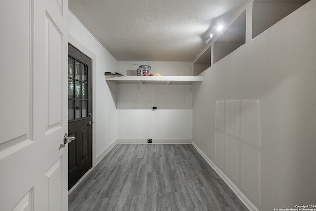 laundry room featuring a textured ceiling and hardwood / wood-style flooring