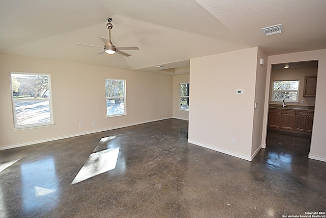 unfurnished room with visible vents, finished concrete floors, vaulted ceiling, ceiling fan, and baseboards