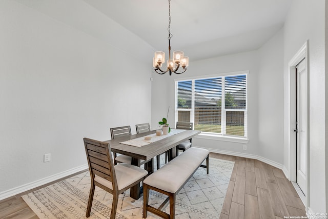 dining area with an inviting chandelier and light hardwood / wood-style flooring