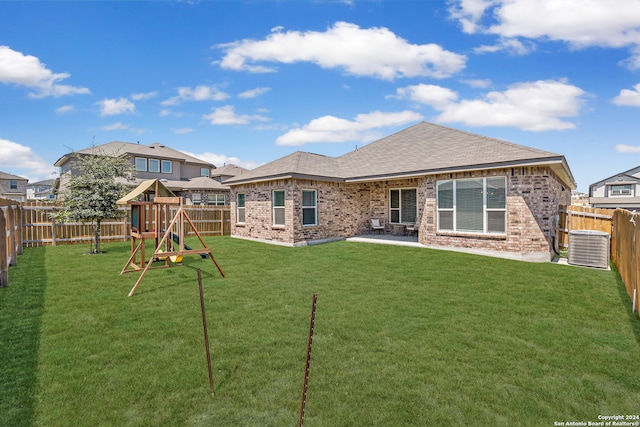 rear view of house featuring a patio area, a yard, cooling unit, and a playground