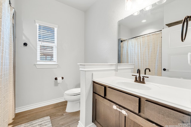 bathroom featuring toilet, hardwood / wood-style floors, and vanity