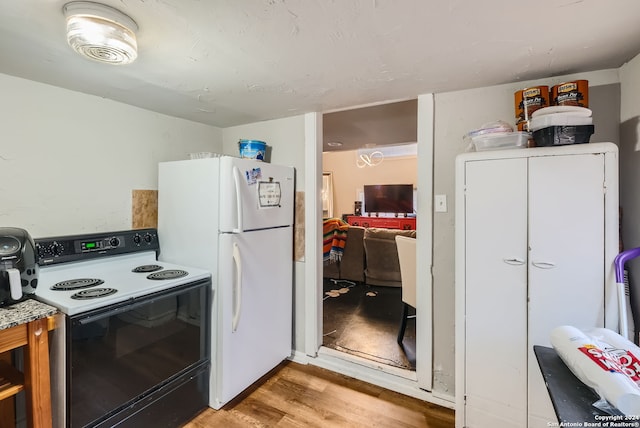 kitchen with white appliances and light hardwood / wood-style flooring