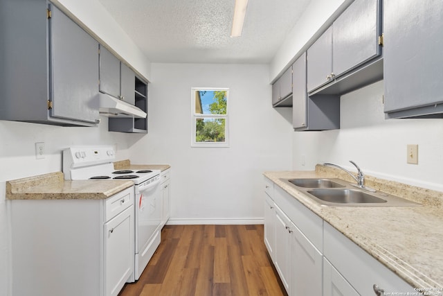 kitchen featuring electric stove, dark wood-type flooring, gray cabinetry, sink, and a textured ceiling