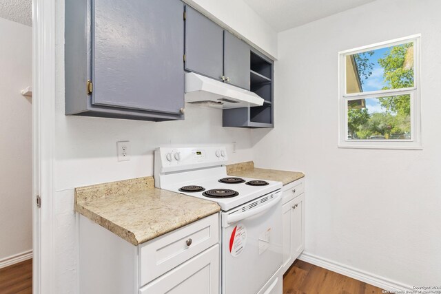 kitchen featuring white range with electric cooktop, dark wood-type flooring, and gray cabinets