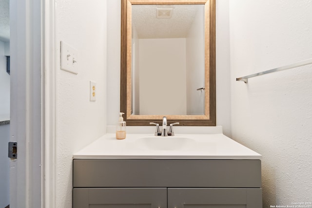 bathroom with a textured ceiling and vanity