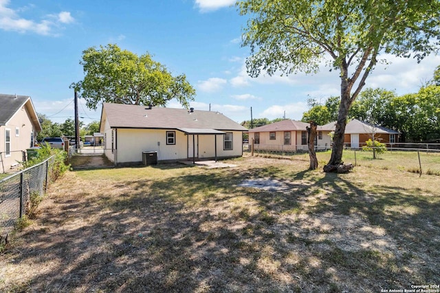 back of house featuring central AC and a lawn