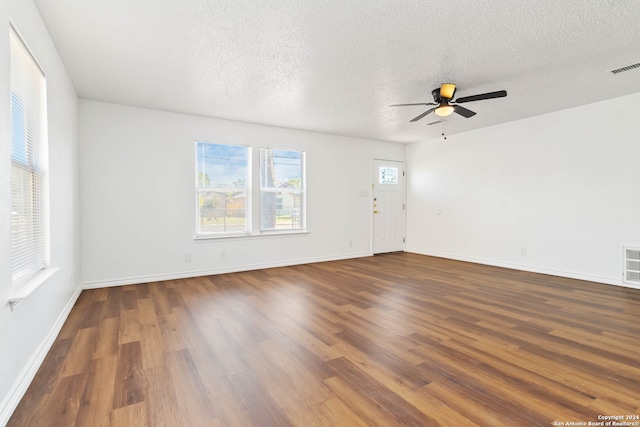 empty room with ceiling fan, hardwood / wood-style flooring, and a textured ceiling