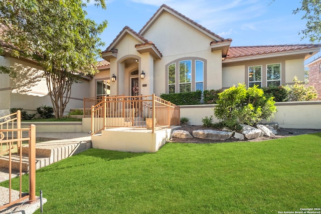 mediterranean / spanish-style home with a front yard