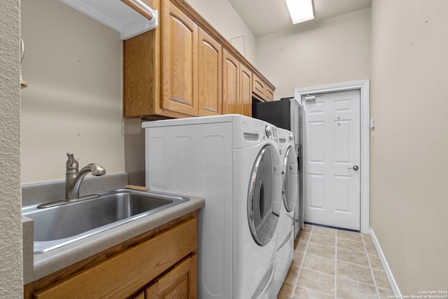 laundry area featuring cabinets, sink, and washing machine and dryer