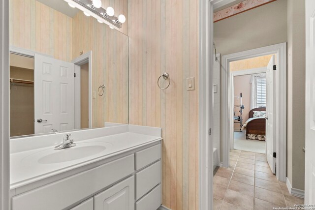 bathroom featuring tile patterned floors, wood walls, vanity, and curtained shower