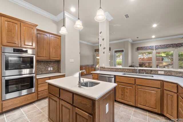 kitchen with an island with sink, crown molding, sink, and stainless steel appliances