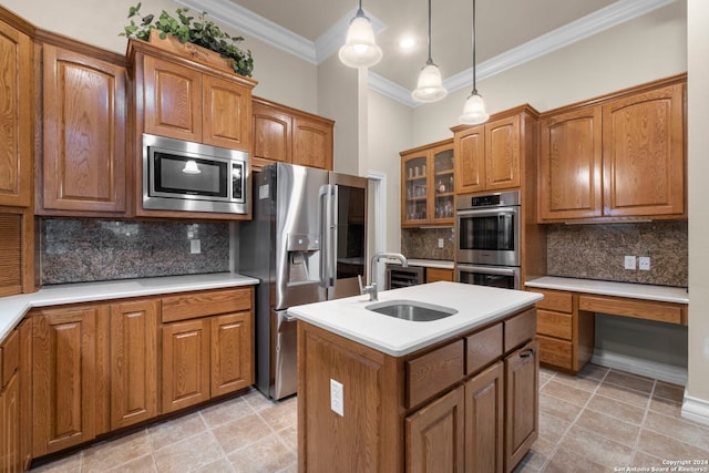 kitchen featuring an island with sink, appliances with stainless steel finishes, backsplash, and sink