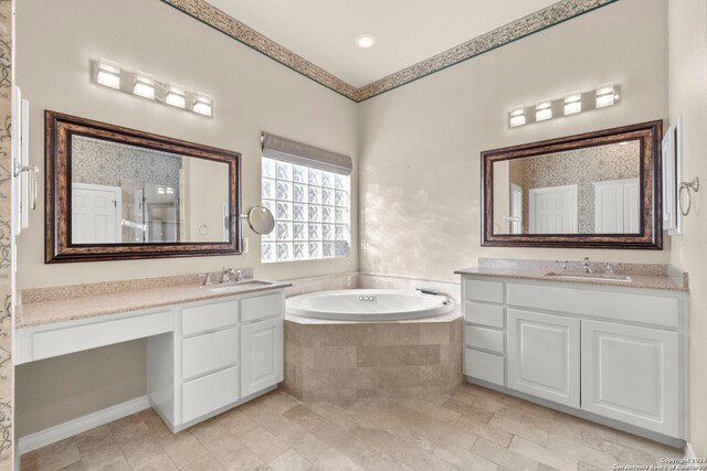 bathroom with tiled tub and vanity