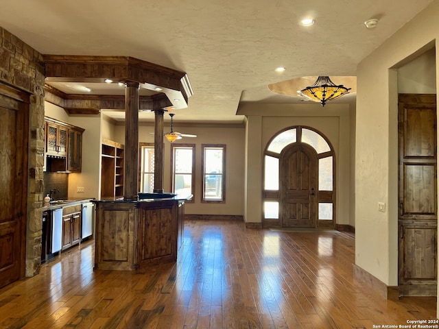 foyer featuring sink, a textured ceiling, decorative columns, and dark wood-type flooring