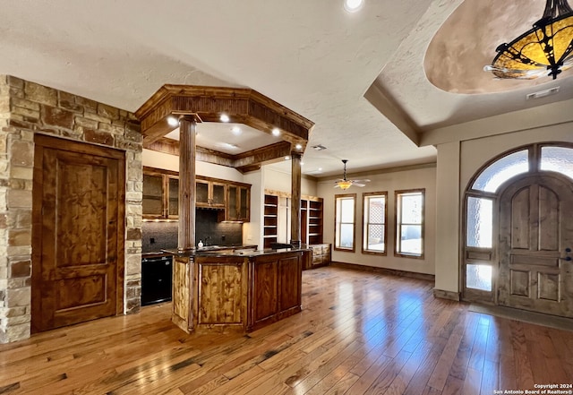 kitchen featuring hardwood / wood-style floors, a center island, decorative light fixtures, ceiling fan, and decorative columns