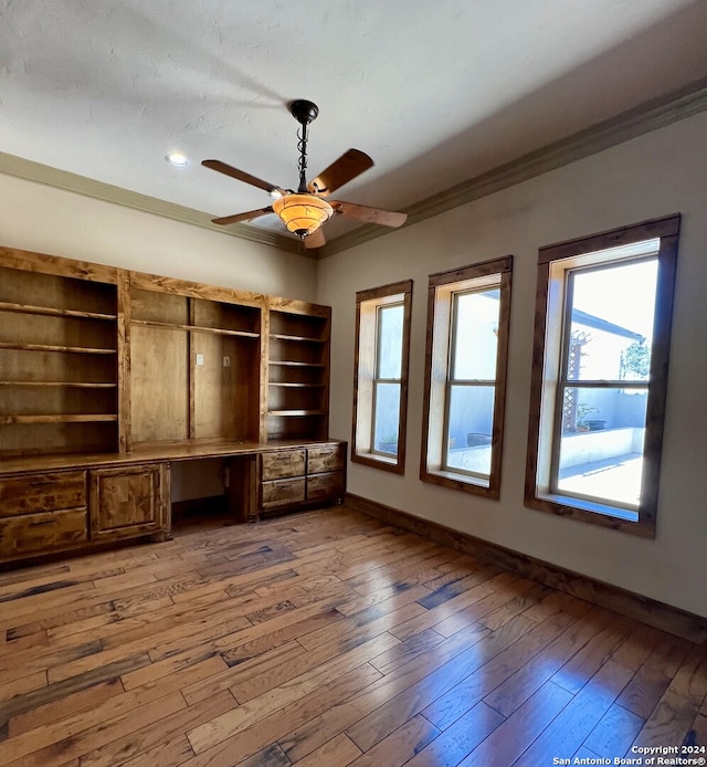 interior space with ceiling fan, ornamental molding, and wood-type flooring