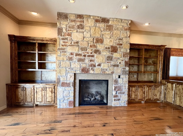 unfurnished living room with a fireplace, crown molding, and wood-type flooring