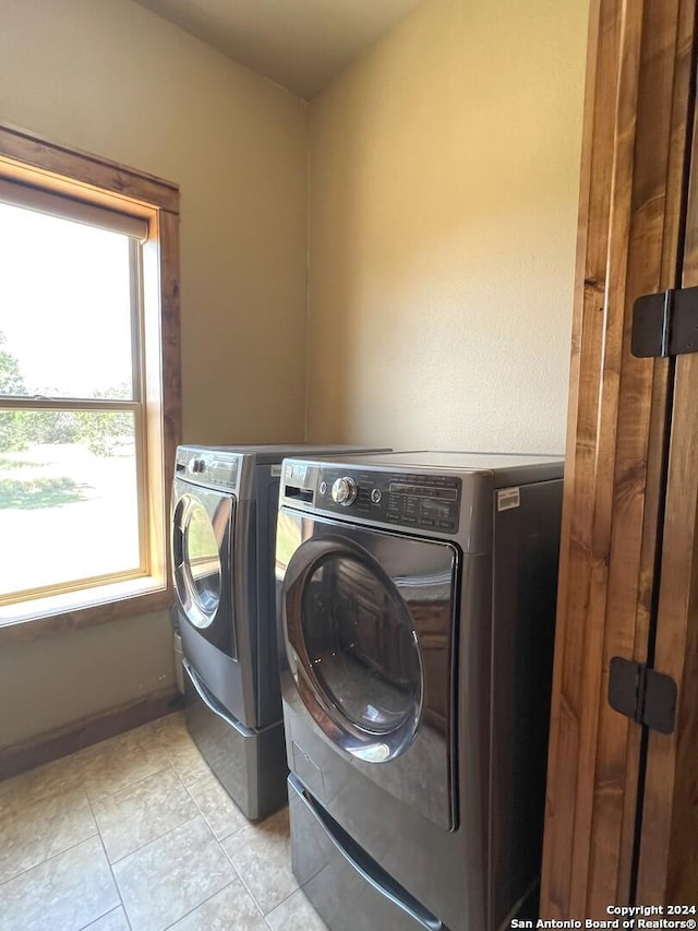 laundry area featuring washing machine and dryer and light tile patterned flooring