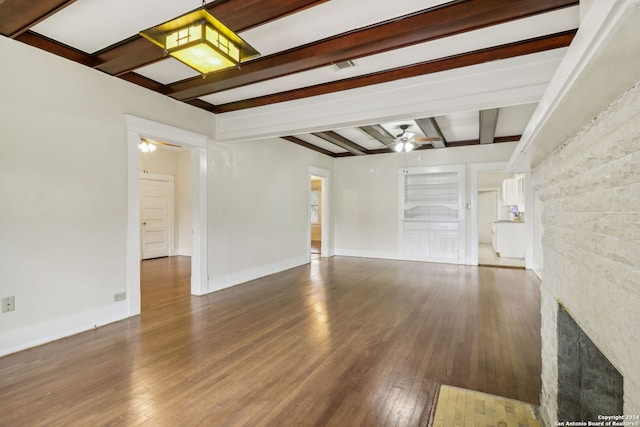 unfurnished living room featuring a fireplace, ceiling fan, beamed ceiling, and hardwood / wood-style flooring