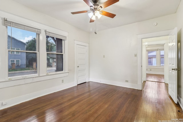 spare room with a wealth of natural light, ceiling fan, and hardwood / wood-style flooring