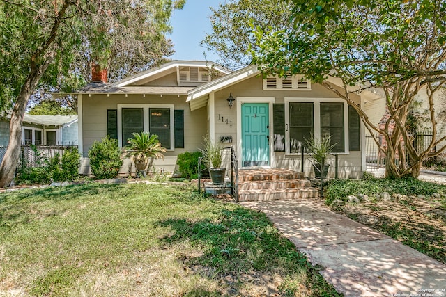 bungalow-style home with a front yard