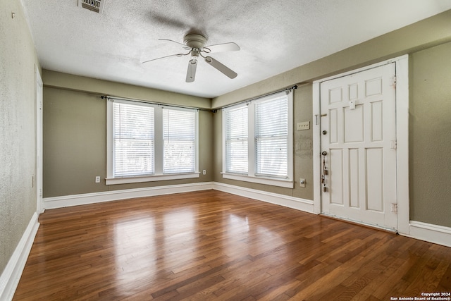 empty room featuring ceiling fan, a textured ceiling, and wood-type flooring