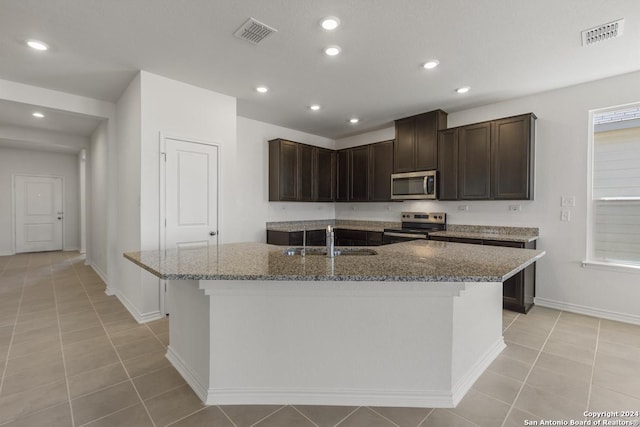 14717 House Wren Fall, San Antonio, TX 78253 - kitchen with stainless steel appliances, visible vents, stone countertops, a kitchen island with sink, and a sink